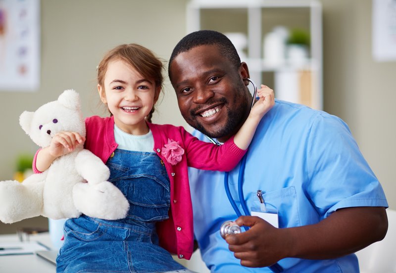 Pediatrician and child patient smiling