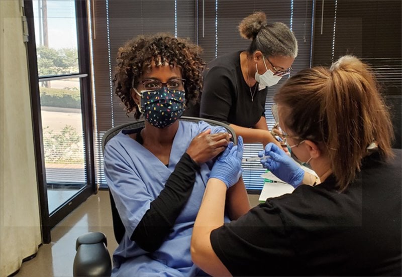 Woman receiving the Covid-19 vaccine from an ARC nurse