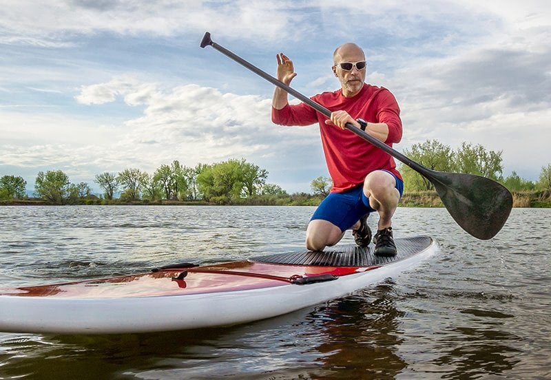 man paddling under the sun