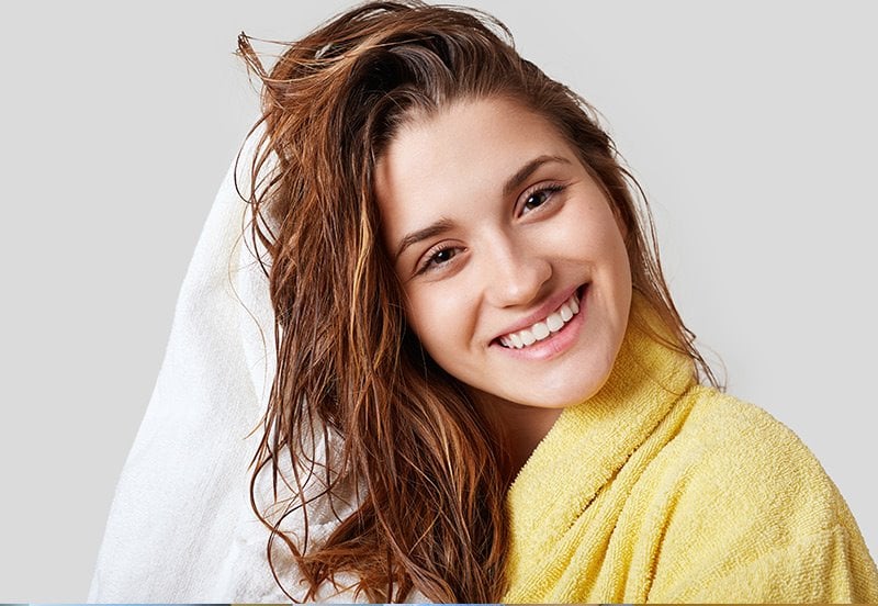 smiling female drying her hair after childbirth